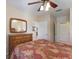 Comfortable bedroom with wood dresser, ceiling fan, and access to the bathroom and closets at 7179 Boca Grove Pl # 202, Lakewood Ranch, FL 34202