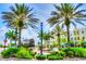 Beautiful community landscape featuring tropical palm trees, lush green foliage, and clear blue skies at 7179 Boca Grove Pl # 202, Lakewood Ranch, FL 34202