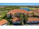 Beautiful condominium featuring a red tiled roof, tropical landscaping, and gorgeous golf course views at 7179 Boca Grove Pl # 202, Lakewood Ranch, FL 34202