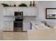 Modern kitchen with white cabinets, updated appliances, and sleek countertops at 7179 Boca Grove Pl # 202, Lakewood Ranch, FL 34202