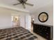 This bright main bedroom offers ensuite access, a ceiling fan, and a convenient hall to the living room at 7179 Boca Grove Pl # 202, Lakewood Ranch, FL 34202