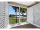 Enjoy the stunning lake and golf course views from this home's large window with bright, white shutters at 7179 Boca Grove Pl # 202, Lakewood Ranch, FL 34202