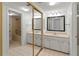 Bright bathroom with double vanity, large mirrors, and a separate area for the tub and toilet at 7500 40Th W Ave # 108, Bradenton, FL 34209