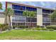 Condo building features a screened lanai, tropical landscaping, and multiple levels of resident balconies at 7500 40Th W Ave # 108, Bradenton, FL 34209
