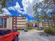 The exterior showcases the building's facade, parking area, blue skies, and mature trees at 7500 40Th W Ave # 108, Bradenton, FL 34209