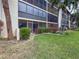 Building exterior showcases a screened lanai, manicured lawn, and lush landscaping with colorful flowering shrubs at 7500 40Th W Ave # 108, Bradenton, FL 34209