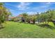 This backyard features a lush lawn, mature tropical landscaping and a screened in pool at 7705 55Th E St, Ellenton, FL 34222