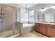 Well-lit bathroom with tiled shower and tub combo, dual vanity and granite countertops at 7705 55Th E St, Ellenton, FL 34222