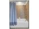This bathroom features tan tiled walls, a shower and tub combo with a blue striped shower curtain at 7705 55Th E St, Ellenton, FL 34222
