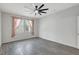 Neutral bedroom with a large window, ceiling fan, and grey, wood-look tile flooring at 7705 55Th E St, Ellenton, FL 34222