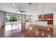 Spacious living room with hardwood floors, ceiling fan, and sliding glass doors to the pool area at 7705 55Th E St, Ellenton, FL 34222