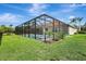 This backyard features a screened-in pool with a spa and lush landscaping at 7705 55Th E St, Ellenton, FL 34222