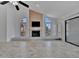 Living room showcasing a brick fireplace, vaulted ceilings, tile floors, and natural light from arch-top windows at 8710 54Th W Ave # 8710, Bradenton, FL 34210