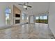 Bright living room featuring a fireplace, fan, neutral tile, and sliding glass doors to the balcony at 8710 54Th W Ave # 8710, Bradenton, FL 34210