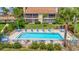 Community pool with comfortable loungers, tables, and lush landscaping, perfect for relaxation and social gatherings at 8710 54Th W Ave # 8710, Bradenton, FL 34210