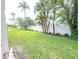 Well maintained backyard with grass, tropical trees, and a white fence at 970 Virginia St # 109, Dunedin, FL 34698