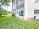 Exterior of property with grass, tropical landscaping, and building with balconies at 970 Virginia St # 109, Dunedin, FL 34698