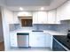 This updated kitchen features stainless steel appliances, white cabinets, and stylish backsplash at 970 Virginia St # 109, Dunedin, FL 34698