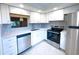 This updated kitchen features stainless steel appliances, white cabinets, and stylish backsplash at 970 Virginia St # 109, Dunedin, FL 34698
