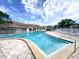 Community pool featuring clear blue waters and stairs descending into the water under a bright blue sky at 970 Virginia St # 109, Dunedin, FL 34698