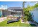 Backyard features a swimming pool surrounded by an enclosure with palm trees at 1021 Estremadura Dr, Bradenton, FL 34209
