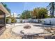 Landscaped backyard featuring a central fire pit, palm trees, and a privacy fence for outdoor enjoyment at 1021 Estremadura Dr, Bradenton, FL 34209