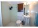Bathroom features a pedestal sink, updated toilet, and tiled shower, offering a clean and functional space at 1021 Estremadura Dr, Bradenton, FL 34209