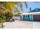 Charming home with a well-kept yard, featuring turquoise siding and a brown garage door at 1021 Estremadura Dr, Bradenton, FL 34209