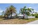 A single story home with tropical landscaping, white fencing and blue skies at 1021 Estremadura Dr, Bradenton, FL 34209