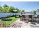 Outdoor entertaining area complete with outdoor kitchen, bar seating and chaise lounge surrounded by lush greenery at 1021 Estremadura Dr, Bradenton, FL 34209
