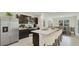 Contemporary kitchen boasts stainless steel appliances, a spacious island, and seamless flow into the dining space at 10845 Gentle Current Way, Parrish, FL 34219