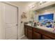 Bathroom with double vanity, granite counters, and a shower with a cloud-themed curtain at 10944 Rainbow Pyrite Dr, Wimauma, FL 33598