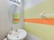Powder room featuring a sleek sink, decorative paint, and oval mirror at 10944 Rainbow Pyrite Dr, Wimauma, FL 33598
