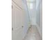 Bright hallway featuring tile flooring, a high ceiling, and a window for natural light at 10944 Rainbow Pyrite Dr, Wimauma, FL 33598