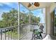 Screened balcony with seating offering beautiful views of mature trees and water at 1100 Imperial Dr # 403, Sarasota, FL 34236
