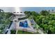 Aerial view showcasing a vibrant community park with a playground, sandy beach, and lush green spaces by the water at 1100 Imperial Dr # 403, Sarasota, FL 34236