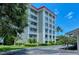 Low angle view of a condominium building on a manicured lawn under a sunny blue sky at 1100 Imperial Dr # 403, Sarasota, FL 34236