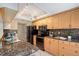 Well-lit kitchen with granite counters, wood cabinets, and modern black appliances at 1100 Imperial Dr # 403, Sarasota, FL 34236