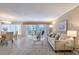 Bright living room with tile flooring, neutral paint, access to a balcony and view of the dining area at 1100 Imperial Dr # 403, Sarasota, FL 34236