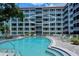 Community pool is in front of the condominium building with many stories and a red roof at 1100 Imperial Dr # 403, Sarasota, FL 34236