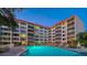 Community pool at dusk has a red roofed condominium in the background at 1100 Imperial Dr # 403, Sarasota, FL 34236