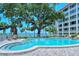 Community pool near the ocean features lounge chairs, tables, and a partially fenced perimeter at 1100 Imperial Dr # 403, Sarasota, FL 34236