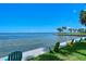 Several Adirondack chairs are on the waterfront near palm trees and blue water at 1100 Imperial Dr # 403, Sarasota, FL 34236