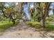 Charming single-story home with a long driveway, lush lawn, and mature trees draped with Spanish moss at 1108 64Th Street E Ct, Bradenton, FL 34208