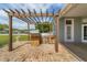 Outdoor kitchen with stainless steel appliances, sink and barbecue grill, all set under a pergola at 1108 64Th Street E Ct, Bradenton, FL 34208