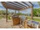 Outdoor kitchen with grill and pizza oven, all set under a pergola at 1108 64Th Street E Ct, Bradenton, FL 34208