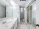 Bathroom with a dual sink vanity, mirrored closet doors, and a walk-in shower at 11717 Wesson E Cir, Tampa, FL 33618