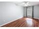 Bedroom featuring hardwood floors, a ceiling fan, and gray curtains framing the window at 11717 Wesson E Cir, Tampa, FL 33618