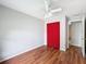 Bright bedroom with hardwood floors, a ceiling fan, and a red closet with curtain doors at 11717 Wesson E Cir, Tampa, FL 33618