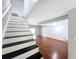 Modern staircase with contrasting black and white design leading to the main living space at 11717 Wesson E Cir, Tampa, FL 33618